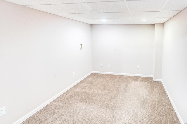 carpeted spare room with a drop ceiling