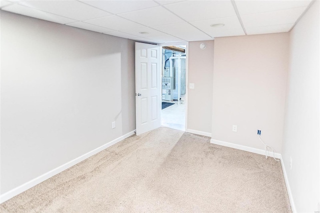 carpeted spare room featuring a drop ceiling