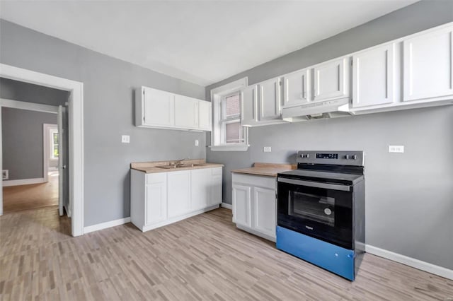 kitchen featuring stainless steel electric stove, white cabinetry, butcher block counters, light wood-type flooring, and sink