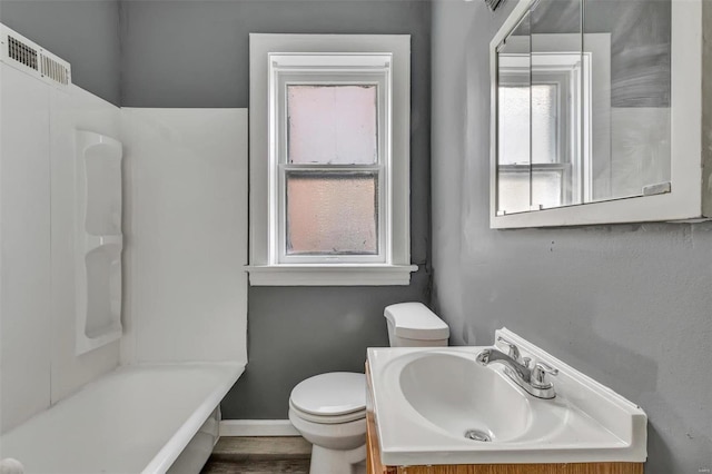 bathroom with vanity, wood-type flooring, a washtub, and toilet