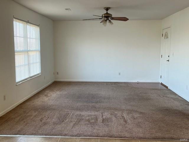 carpeted spare room with ceiling fan