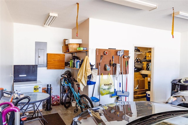 interior space featuring electric panel, a workshop area, and concrete flooring