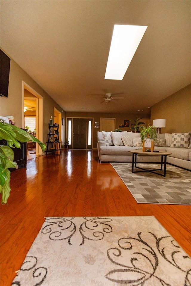 living room with wood finished floors and a skylight