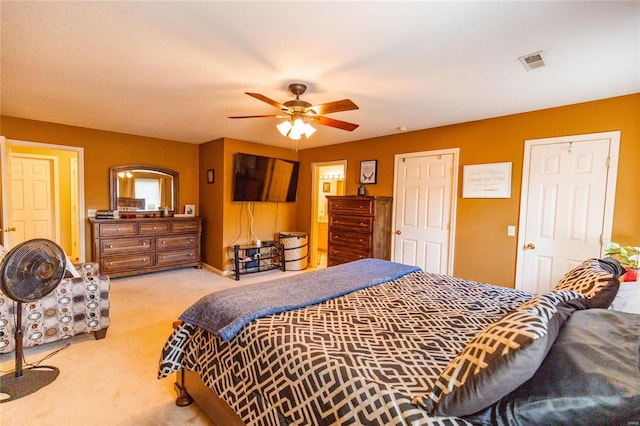 bedroom featuring visible vents, light colored carpet, and ceiling fan