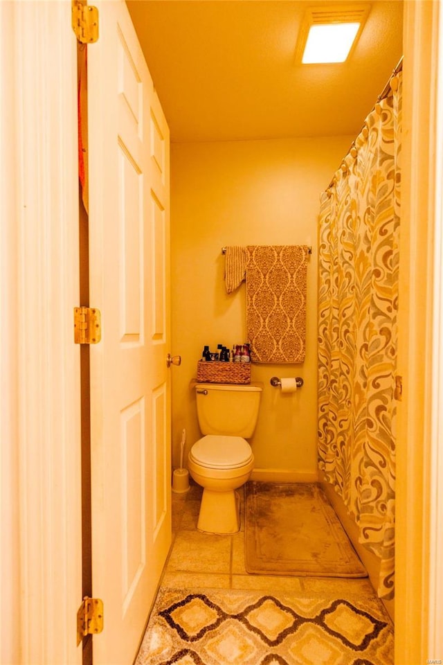 full bath featuring tile patterned floors, toilet, a shower with shower curtain, and baseboards