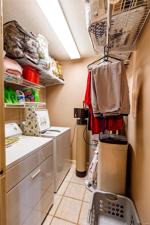 washroom featuring washer and dryer, laundry area, and light tile patterned floors