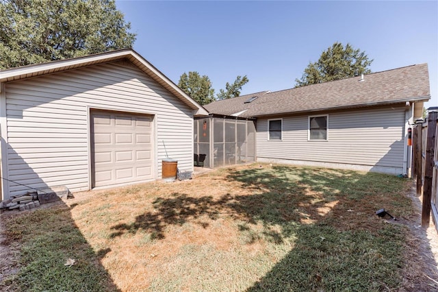 view of yard with driveway, fence, an outdoor structure, a sunroom, and a garage