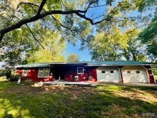 single story home featuring driveway, an attached garage, and a front yard