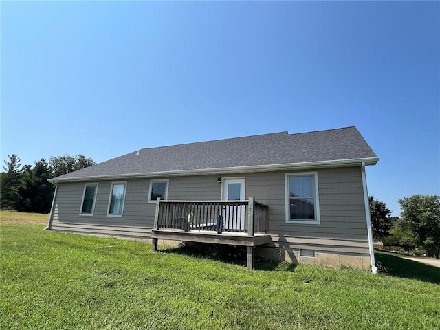 rear view of property featuring a deck and a lawn