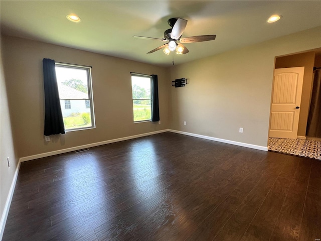 spare room featuring ceiling fan and dark hardwood / wood-style flooring