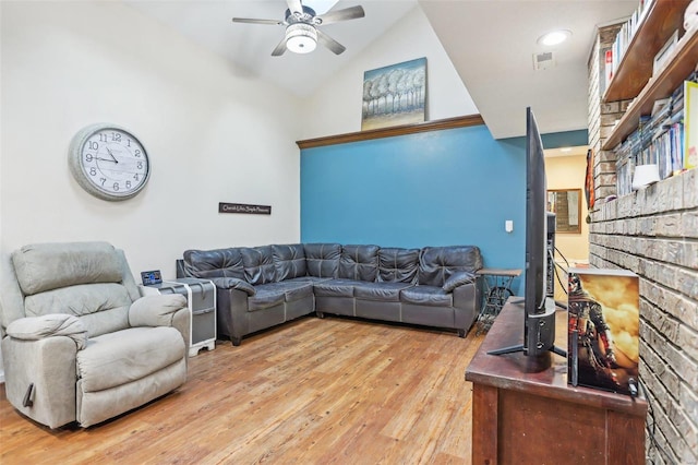 living room featuring hardwood / wood-style flooring, ceiling fan, and vaulted ceiling