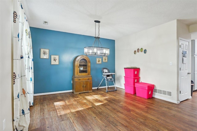 interior space with a chandelier, a textured ceiling, and dark hardwood / wood-style floors