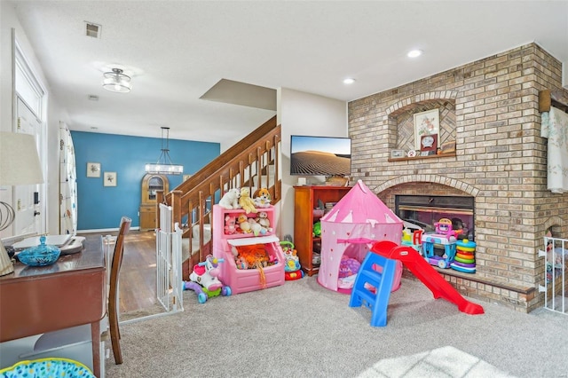 recreation room with carpet flooring and a fireplace