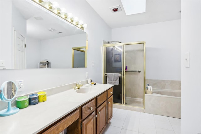 bathroom featuring separate shower and tub, vanity, a skylight, and tile patterned floors