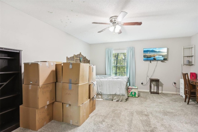 carpeted bedroom featuring a textured ceiling and ceiling fan