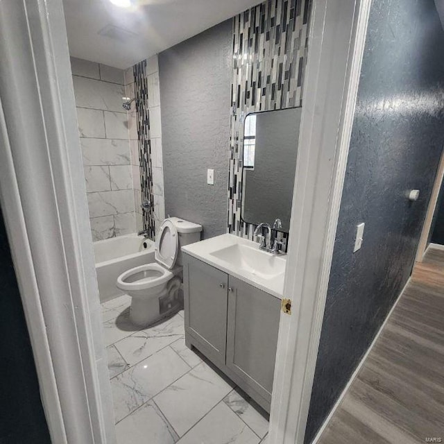 full bathroom featuring vanity, toilet, wood-type flooring, and tiled shower / bath