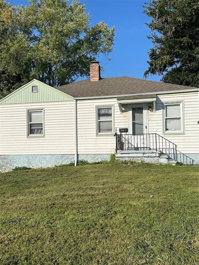 rear view of property with a lawn