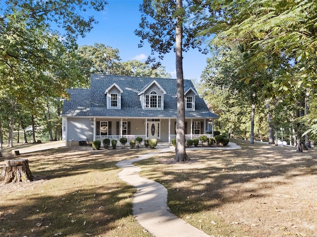 new england style home with covered porch and a front yard