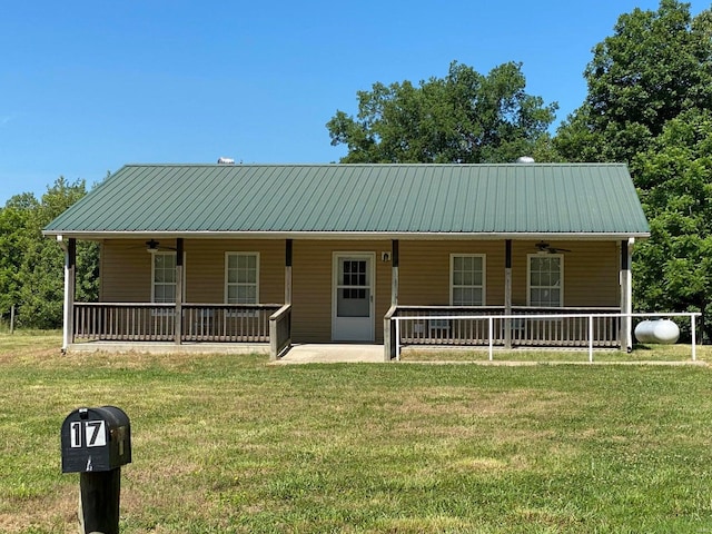 view of front of home with ceiling fan, covered porch, and a front yard