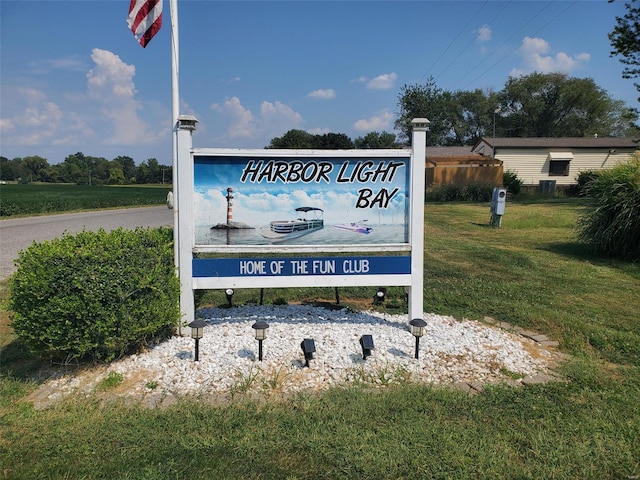 community / neighborhood sign featuring a lawn