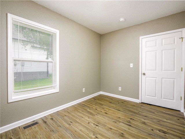 unfurnished room with hardwood / wood-style flooring