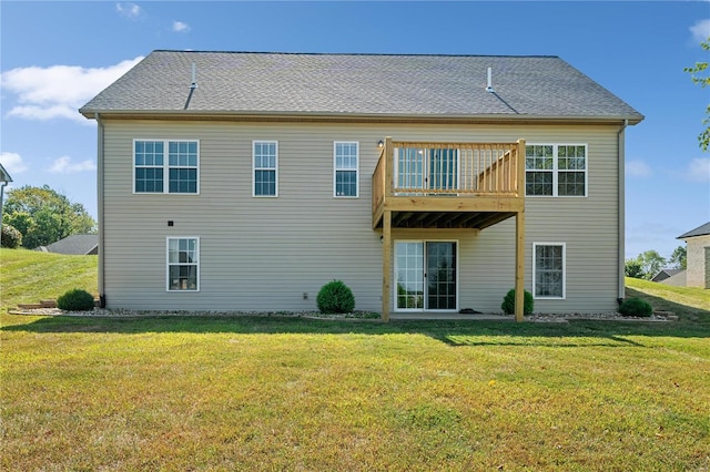 rear view of property featuring a lawn and a balcony