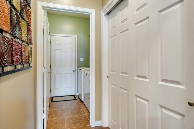 hall with independent washer and dryer and light tile patterned floors