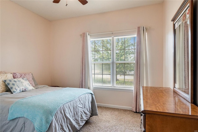 bedroom featuring light carpet, multiple windows, and ceiling fan