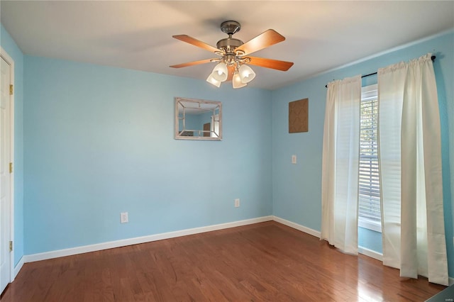 empty room featuring dark wood-type flooring and ceiling fan