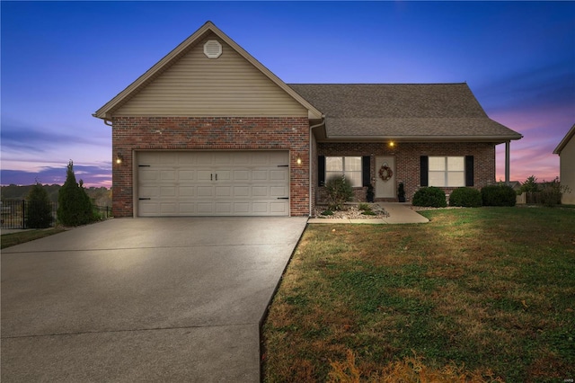 ranch-style house with a garage and a lawn