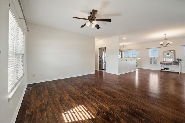 unfurnished living room featuring dark wood-type flooring and ceiling fan with notable chandelier