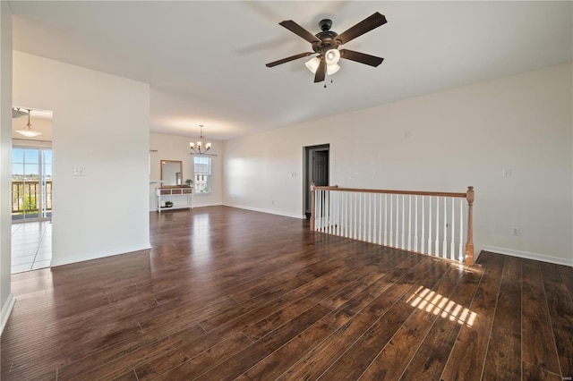 unfurnished living room featuring dark wood-type flooring and ceiling fan with notable chandelier