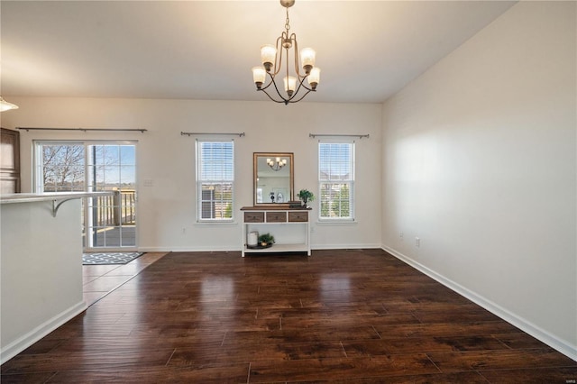 unfurnished dining area featuring a healthy amount of sunlight, a chandelier, and dark hardwood / wood-style floors