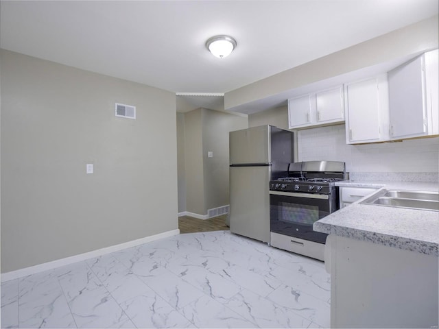 kitchen featuring stainless steel appliances, decorative backsplash, sink, and white cabinetry