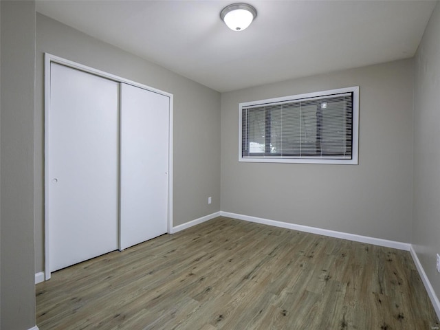 unfurnished bedroom featuring light wood-type flooring and a closet