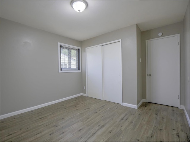 unfurnished bedroom with a closet and light hardwood / wood-style floors