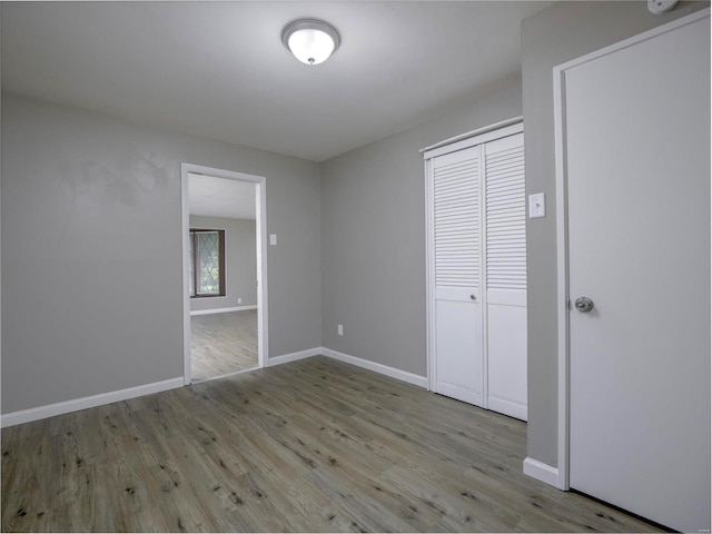 unfurnished bedroom with a closet and light hardwood / wood-style floors