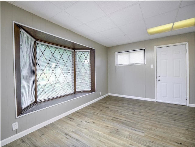 spare room featuring a drop ceiling and hardwood / wood-style floors