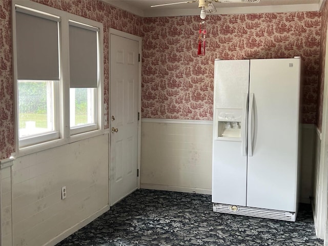 interior space with ceiling fan and white fridge with ice dispenser