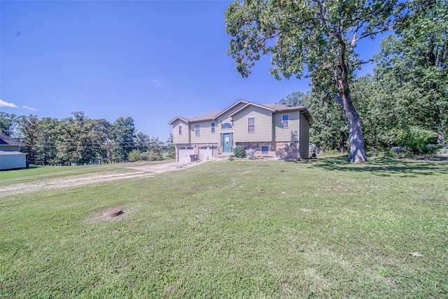 raised ranch featuring a garage and a front yard