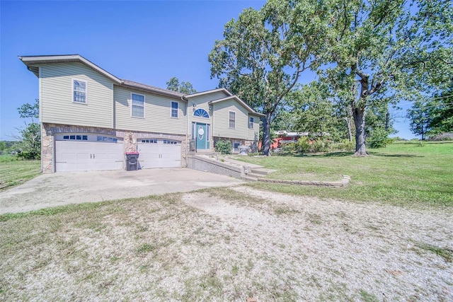 raised ranch featuring a garage and a front lawn