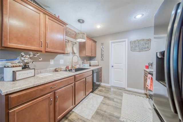 kitchen featuring sink, black dishwasher, stainless steel fridge with ice dispenser, light hardwood / wood-style flooring, and pendant lighting