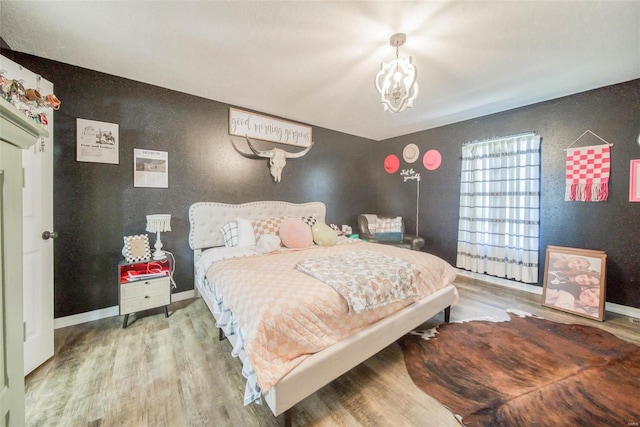 bedroom with a chandelier and hardwood / wood-style flooring