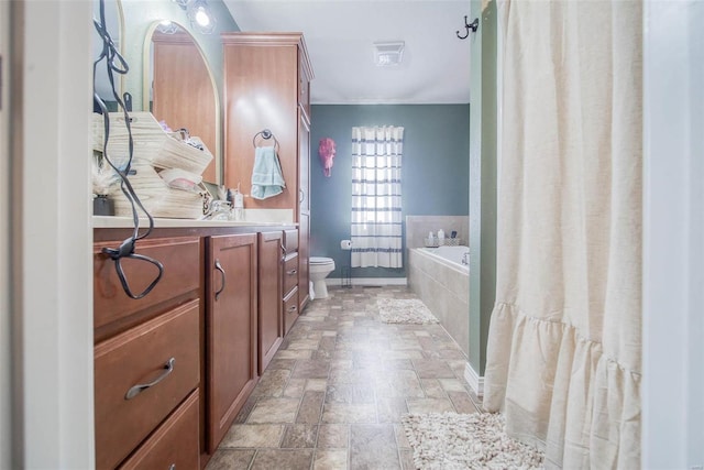 bathroom featuring vanity, toilet, and tiled bath