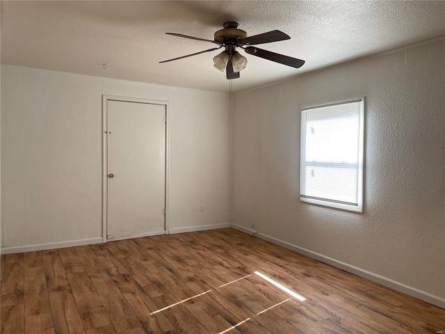 spare room with ceiling fan, wood-type flooring, and a textured ceiling