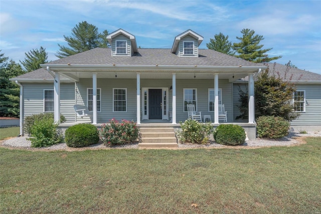 cape cod house featuring roof with shingles, covered porch, and a front yard