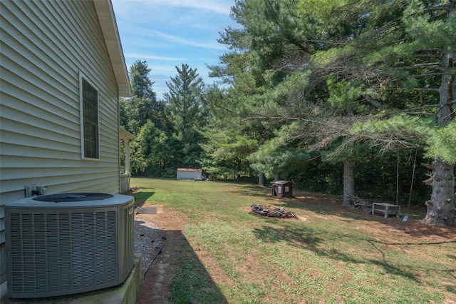 view of yard featuring central air condition unit and a fire pit