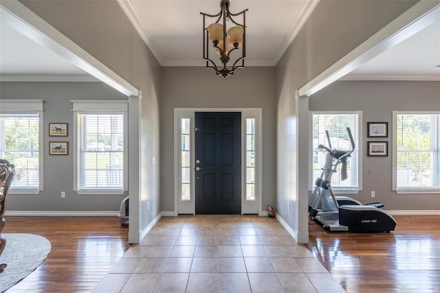 entrance foyer with wood finished floors, plenty of natural light, and ornamental molding