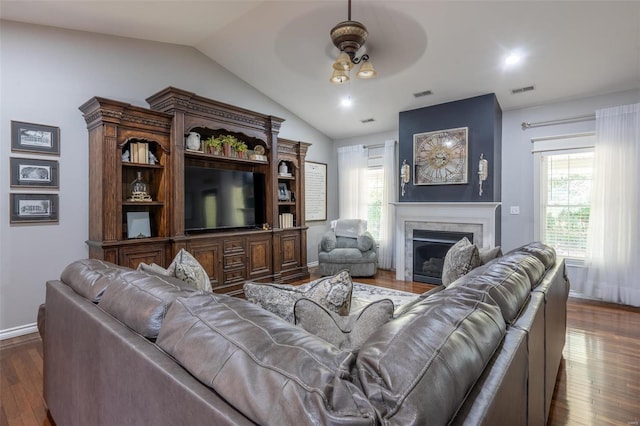 living room featuring visible vents, ceiling fan, lofted ceiling, a fireplace, and wood finished floors