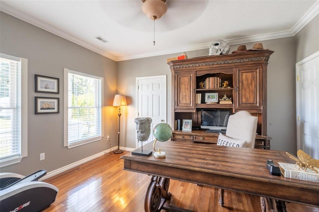 office space with light wood-type flooring, baseboards, visible vents, and ornamental molding